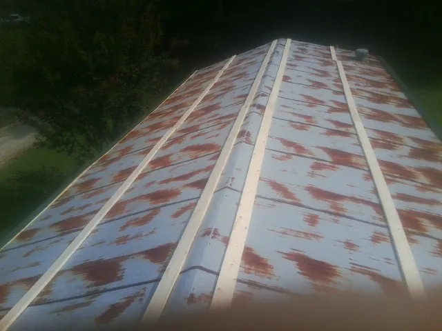Rusted metal roof panels with new wood purlins before replacement — Storm Damage Roof Repair in New Raymer by Roofing Brothers