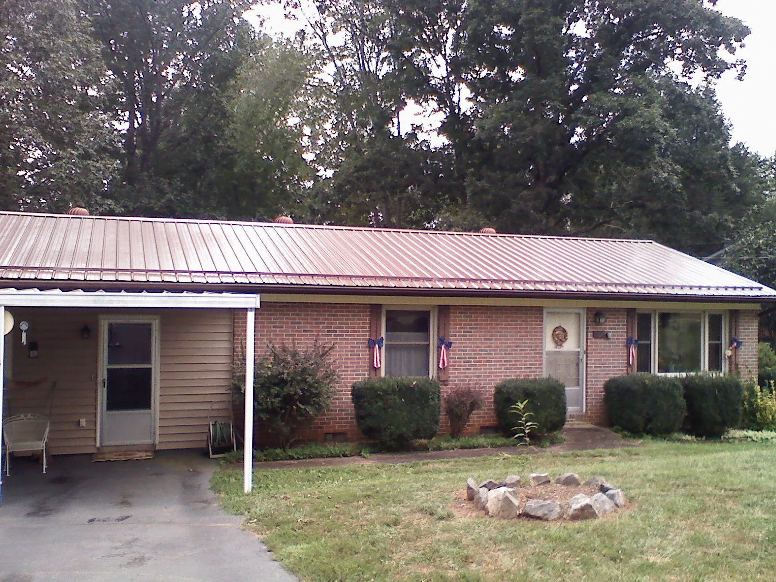 Bronze metal roof and carport on a brick ranch home — Roof Repair work by our crew in New Raymer